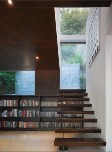 Ebony-stained oak bookshelves and wall and ceiling paneling contrast with the white epoxy resin floor in the library area of a Hollywood Hills residence renovated by Griffin Enright Architects. Photograph by Benny Chan, Fotoworks