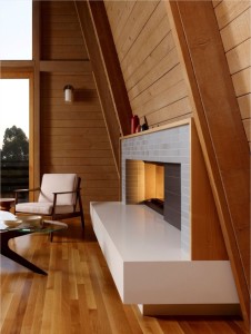 Unstained white oak flooring and alder plank walls create a warm cocoon around the fireplace in an Oakland, California living room renovated by Burton Architecture. Photograph by Cesar Rubio