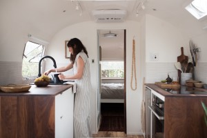 The galley kitchen in a 1977Airstream Overlander renovated by The Modern Caravan features custom walnut counters and cabinetry. Photograph by Kate Oliver