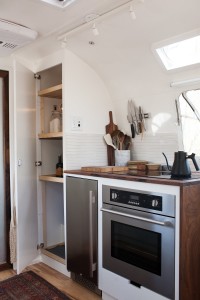 Built-in kitchen appliances include a 3.3-cubic-foot built-in refrigerator, a convection oven—both in stainless steel—and a dual-burner induction cooktop. Photograph by Kate Oliver