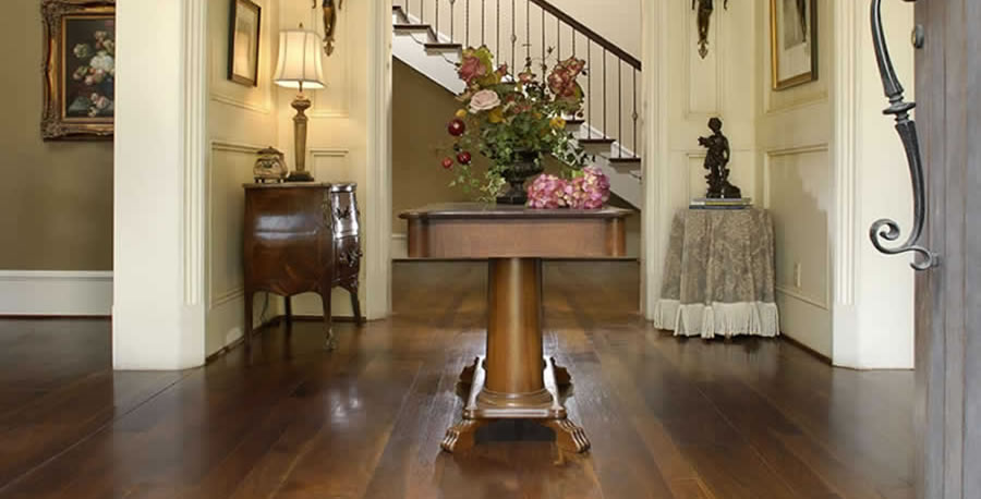 Wide-plank walnut flooring by Carlise makes a lustrous statement in a tradional entry hall.