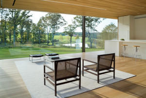 White oak ceilings and floors frame the spectacular view from the living, dining, and kitchen area of the LM Guest House in Duchess County, New York, by Desai Chia Architecture.
