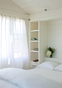 Painted poplar shiplap walls and built-in shelving in the guest room of a Nantucket Island beach house renovated by Moger Mehrhof Architects with millwork by Woodmeister Master Builders. Photograph by Greg Premru