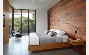 A wall of American black walnut and a platform bed, nightstands, and media wall of white oak feature in the master bedroom of a house in Austin, Texas, by Cornerstone Architects. Photograph by Andrew Pogue