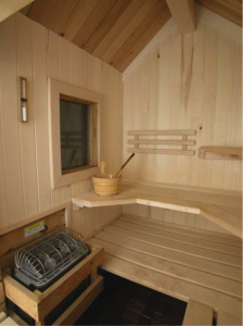 An outdoor sauna in white aspen with a vaulted ceiling and a window. Superior Sauna & Steam