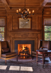 Quarter-sawn oak paneling and coffered ceiling surround a gas log fireplace in the library of a Shingle Style vacation house at Lake Keowee, South Carolina, designed by architect Stephen Fuller and constructed by Gabriel Builders. Photograph by TJ Getz