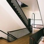 The second floor hallway and double staircases in the three-story Centre Family Dwelling at Pleasant Hill. The floor is ash. 