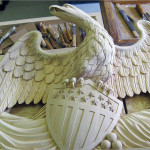 The frame’s imposing American eagle center crest with its shield, draped flags, and other patriotic symbols was hand carved in basswood by master carver Félix Terán, who comes from a family of woodcarvers in San Antonio de Ibarra, Ecuador.